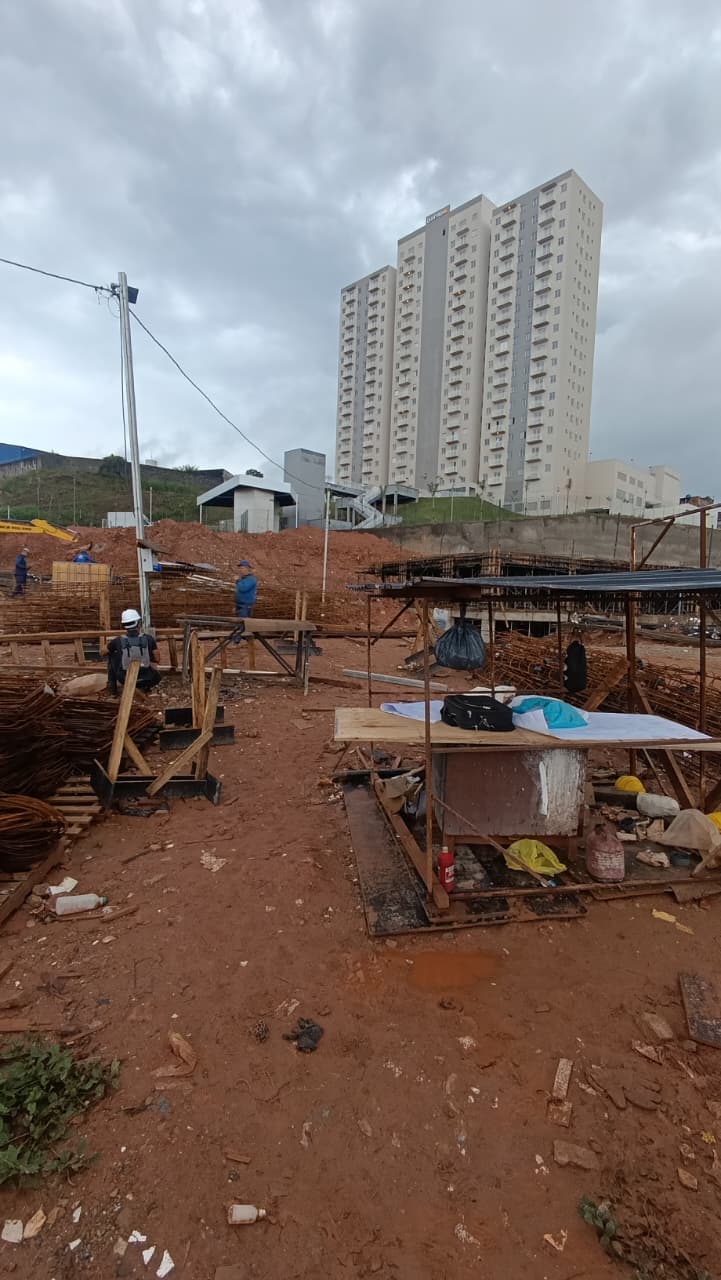 Engenheiro Oira em vistoria de campo ao lado de poste de iluminação e quadro elétrico em obra de condomínio no ABC Paulista